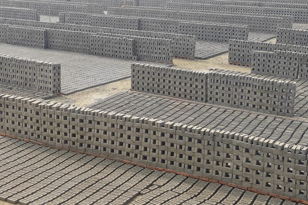 a-large-group-of-cinder-blocks-sitting-on-top-of-a-cement-floor-qnvfmtpus0y