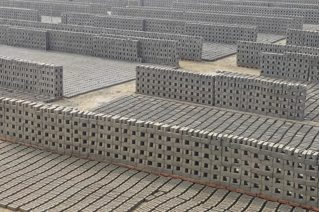 a-large-group-of-cinder-blocks-sitting-on-top-of-a-cement-floor-qnvfmtpus0y